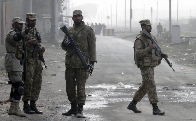 Pakistan Army troops stand guard at a road leading to the central prison on the outskirts of Lahore. (Associated Press)